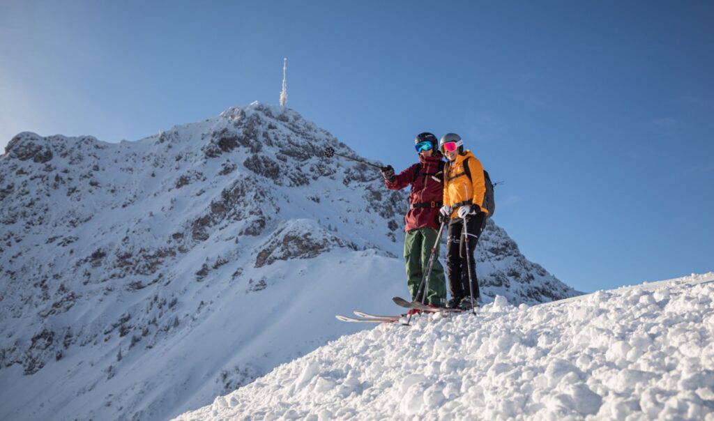 A pair of skiers survey the slope