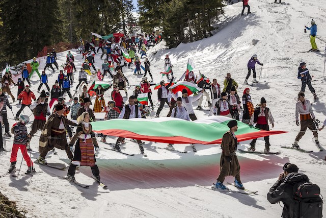 Bulgarians ski down mountain holding national flag