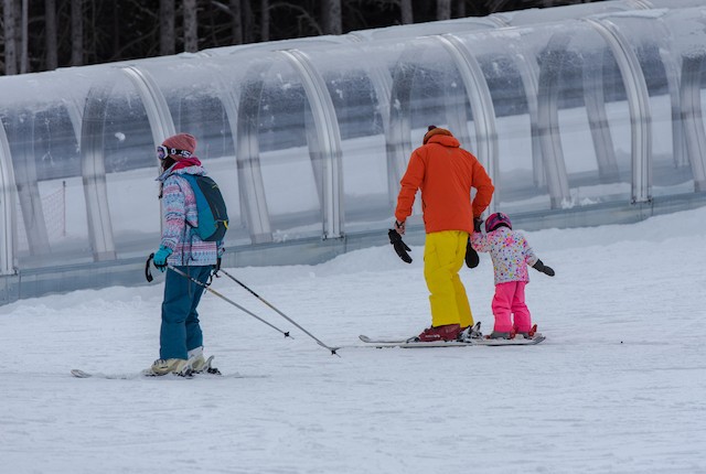 Adult teaching child skiing in Andorra