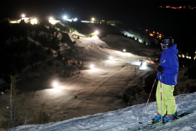 Night skiing as skier overlooks piste